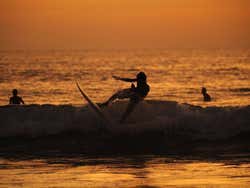 Surfers on Kuta Beach at sunset